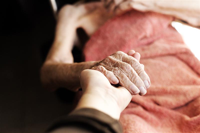 Zwei sich haltende Hände als Symbol für Begleitung in der Palliativpflege